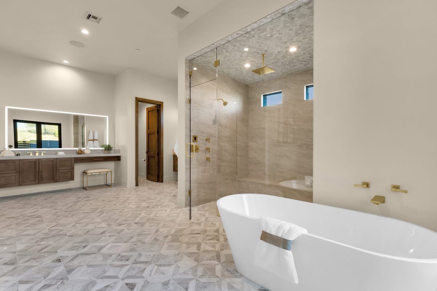 Master bathroom suite with a freestanding tub, walk-in travertine shower and geometric marble mosaic floor