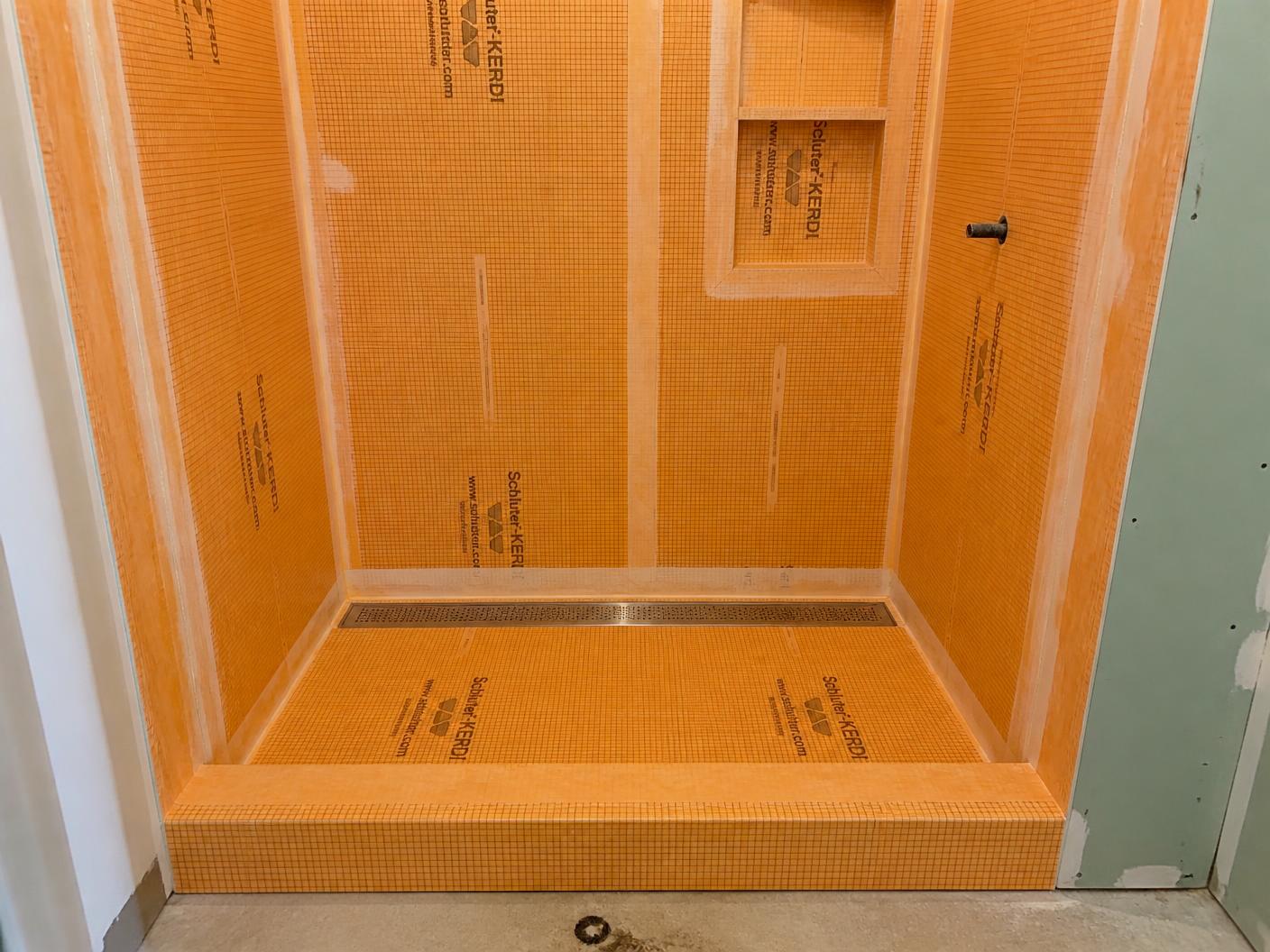 Schluter waterproofing membrane installed over shower walls, pan and niche